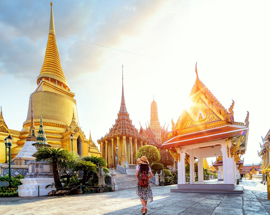 A women standing in front of the magestic Grand Palace in Bangkok - Thai Pass