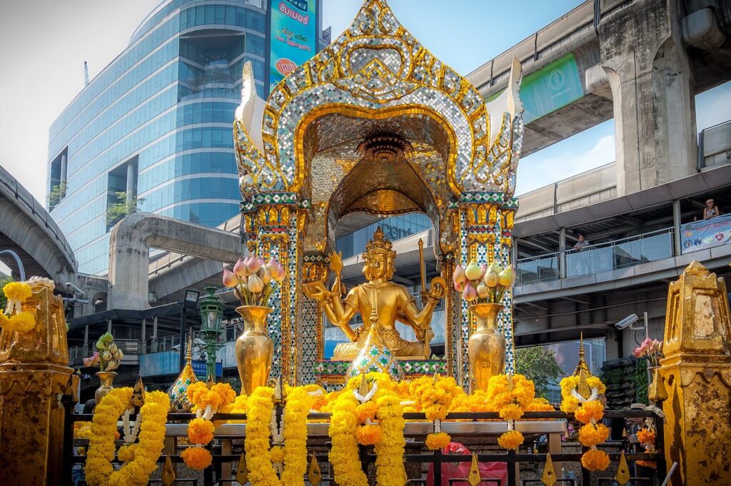 A golden statue with yellow garlands at the Erawan Shrine in Bangkok - Thai Pass