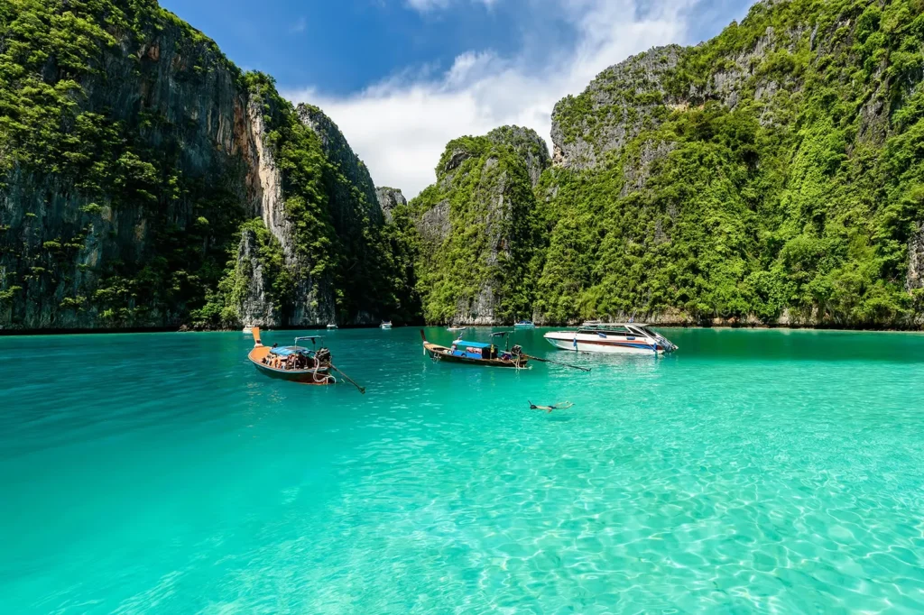 Long Tail boats and a speedboat near Phi Phi Islands - Thai Pass