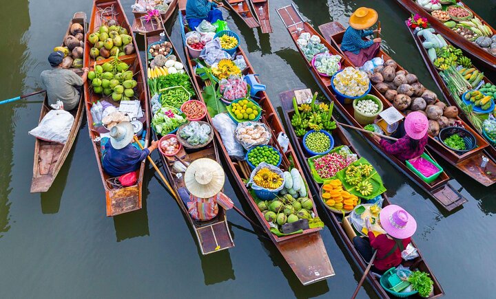 Vendors on boats with fruits and vegetables in Damnoen Saduak Market - Thai Pass