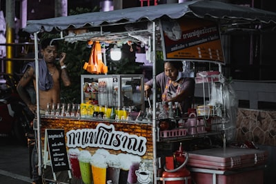 A man standing behind a food cart selling drinks in Pattaya - Thai Pass