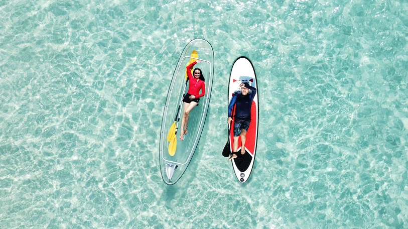 Overhead view of two people on kayaks on clear turquoise water - Thai Pass